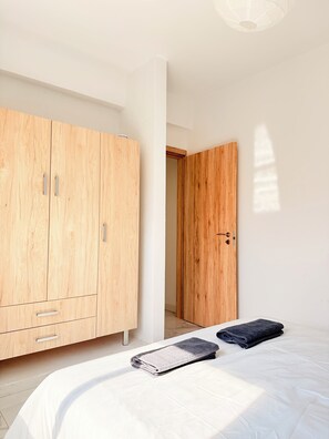 Une chambre à coucher avec un lit, une armoire en bois et une porte.