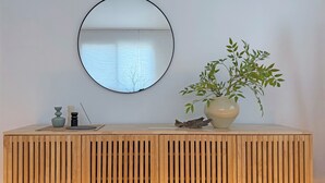 A wooden console with a mirror, a vase with green leaves, and two small vases. - Family-sized | Premium Stay | Near Incheon Airport | 5 minutes to Unseo Station (Incheon)