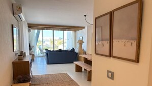 A spacious living area with a sofa, a wooden bench, a rug, and a wall-mounted air conditioner. - Fouka North Coast CL9-CH22-01 (Marsa Matrouh)