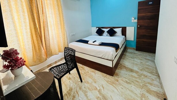 A bedroom with a bed, a desk, a chair, and an air conditioning unit. - S K Comforts Rooms (Bengaluru)