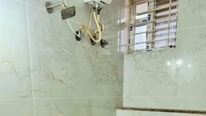 A bathroom with a shower, a toilet, and a sink. - S K Comforts Rooms (Bengaluru)