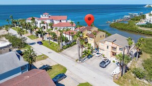 A coastal residential area with houses, a marina, and a clear view of the ocean. - Large Family Condo w/ Private Balcony Overlooking the Bay! (South Padre Island)