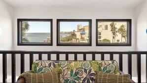 A room with a bed, a view of the sea, and three framed pictures on the wall. - Large Family Condo w/ Private Balcony Overlooking the Bay! (South Padre Island)