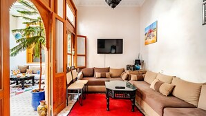 A living room with a sofa, coffee table, and a TV.