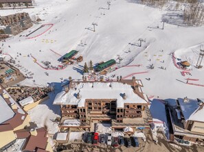 A ski resort with multiple buildings, ski lifts, and a parking area. - Ski, Bike & Hike | Ultimate On-Mountain Location! (Mt Crested Butte)