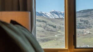 A window with a view of a mountain range and a forested valley. - Vista Rubino. Bright Timberline condo with lift access, views, trails, and shuttle. (Mt Crested Butte)