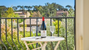 A balcony with a table, a bottle of wine, and two glasses. - Villa Rosa Lia, swimming pool, pétanque, near the sea (Carqueiranne)
