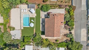 An aerial view of a residential property with a swimming pool, patio area, and a tiled-roofed house. - Villa Rosa Lia, swimming pool, pétanque, near the sea (Carqueiranne)