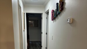 Ein Korridor mit Holzboden, weißen Wänden und einer Deckenleuchte.