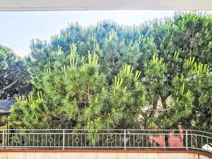 Ein Baum mit dichtem Blätterwerk vor einem Gebäude.