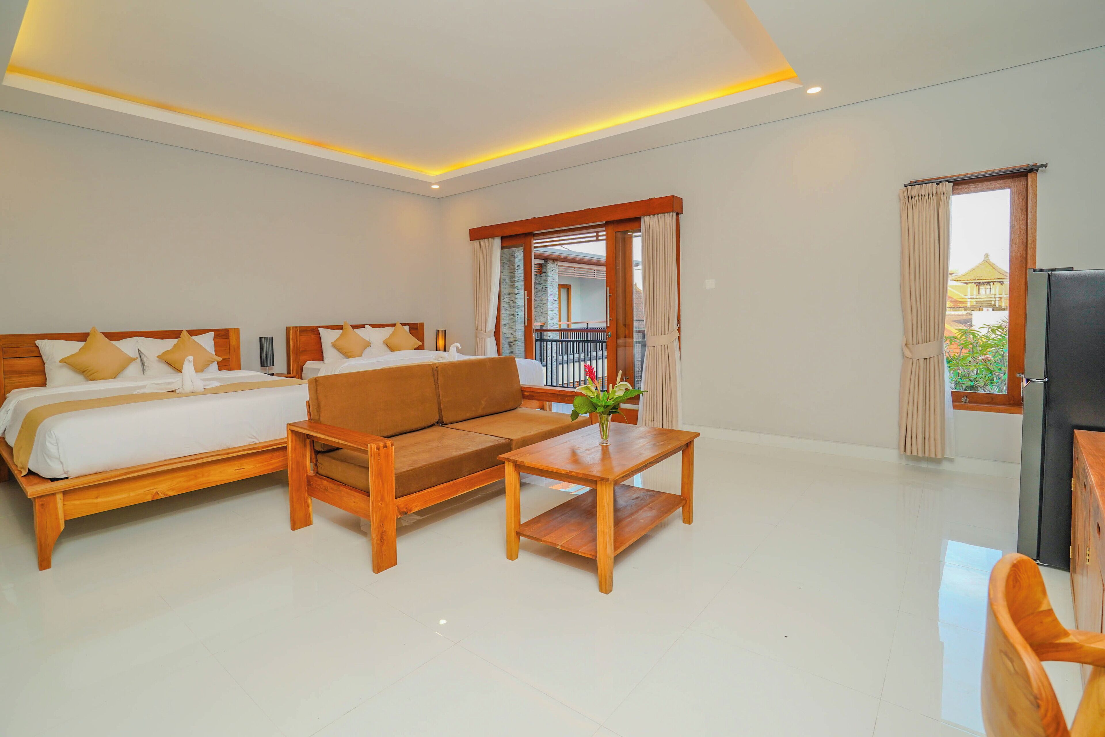 A hotel room with a bed, sofa, coffee table, and a TV.