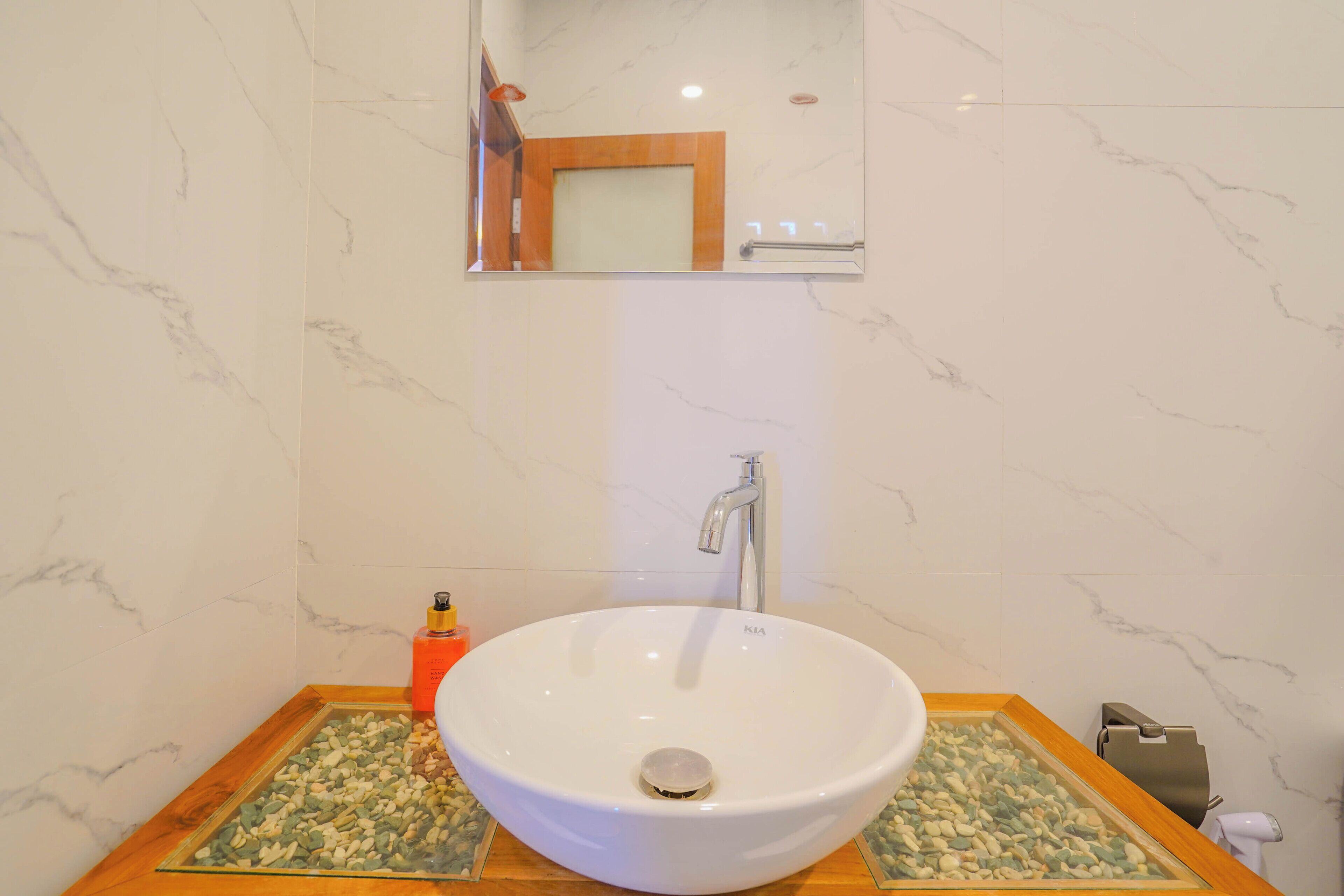 A bathroom with a white sink, a mirror, and a towel rack.