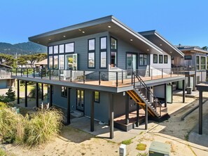 A modern two-story house with a balcony, large windows, and a staircase. - Amazing Oceanview home with indoor basketball court, easy beach access (Manzanita)