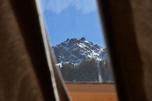 Ein Berg, sichtbar durch ein Fenster mit blauem Himmel.