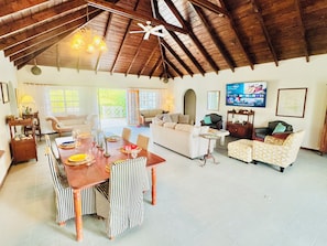A spacious living area with a high ceiling, a dining table set for four, and a comfortable seating arrangement. - Large estate Villa 6-bed / 6 bath, perfect for large groups & 2 arces of graden (Charlestown)