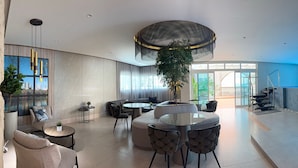 En rymlig entréhall med modern design, med en stor sittgrupp, en trappa och utsikt över omgivningarna.