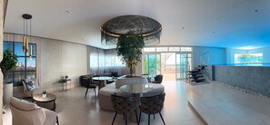 Un vestíbulo amplio con diseño moderno, que cuenta con una zona de estar grande, una escalera y vistas al exterior.