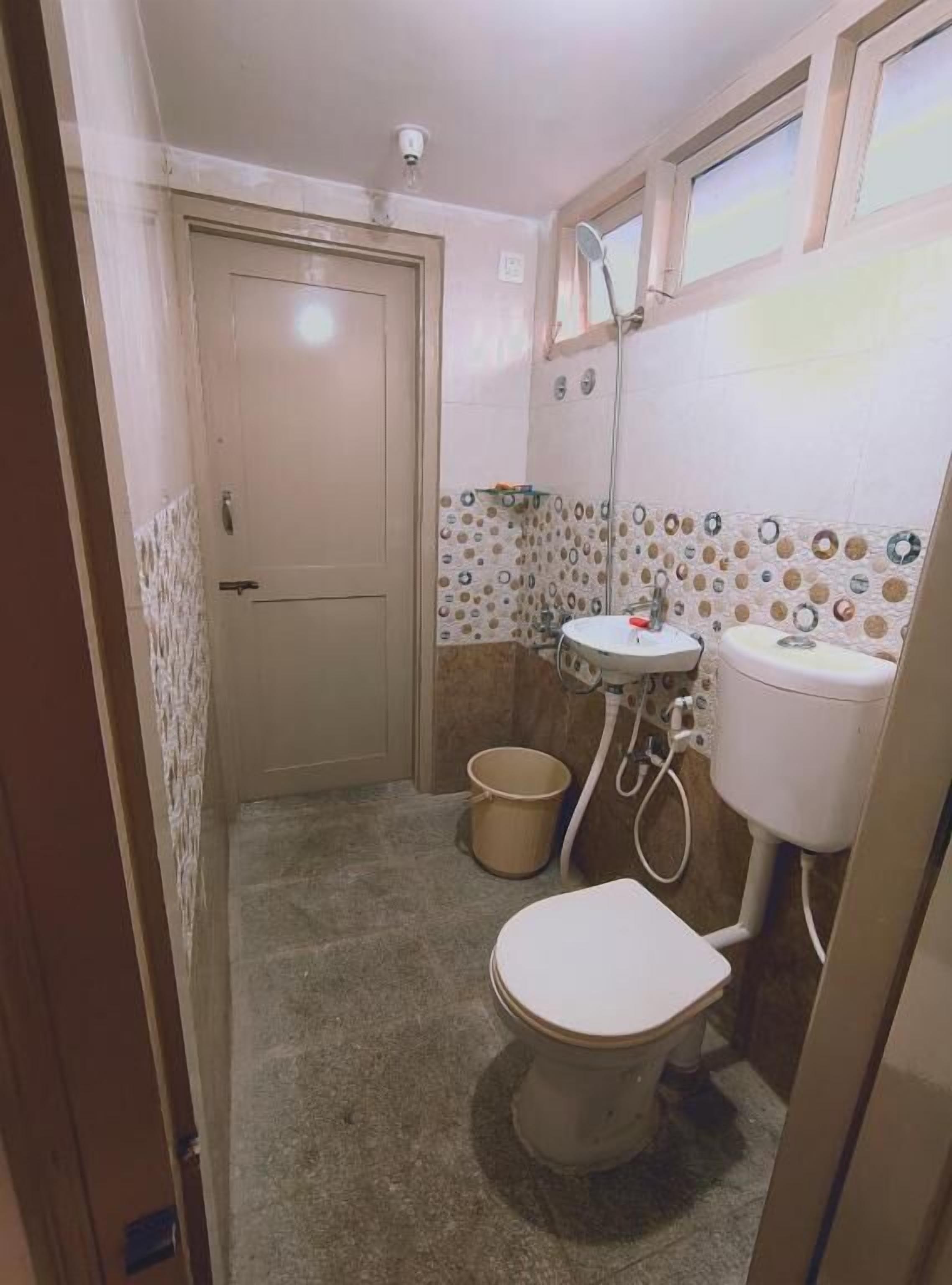 A small bathroom with a toilet, sink, and shower.