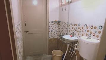A small bathroom with a toilet, sink, and shower.