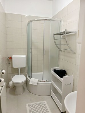 A bathroom with a toilet, shower, and sink. - Seafront Studio on the Island of Rab (Rab)