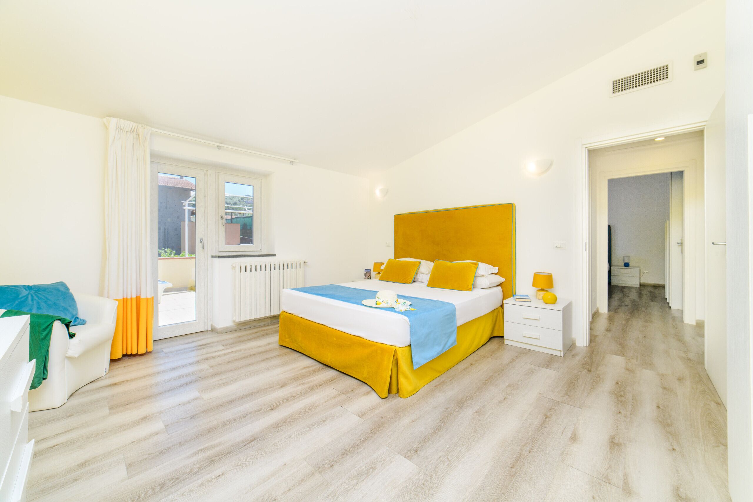A bedroom with a bed, bedside table, and a window.