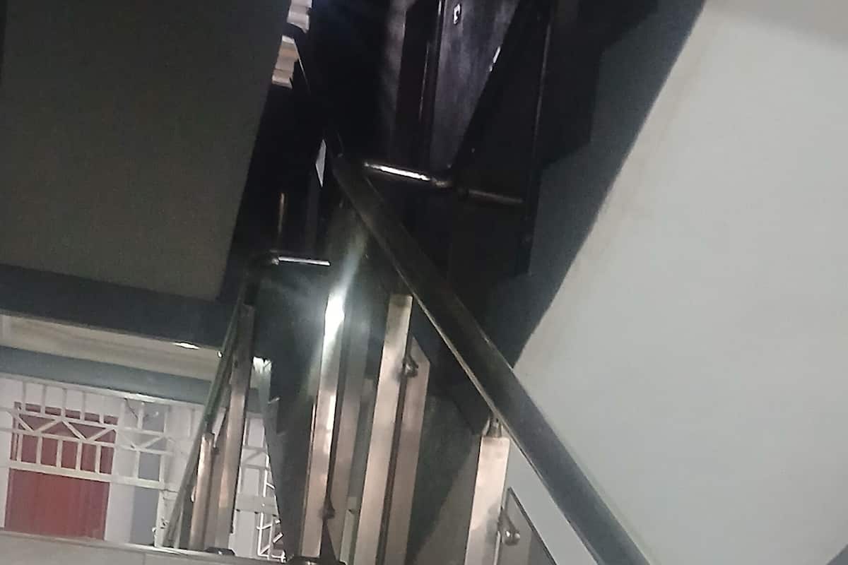 Una escalera con barandillas de metal y peldaños de cerámica.