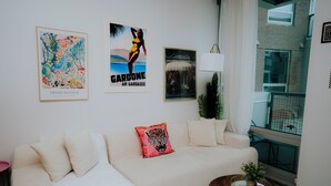 Ein modernes Wohnzimmer mit einem weißen Sofa, einem Couchtisch und Bildern an der Wand.