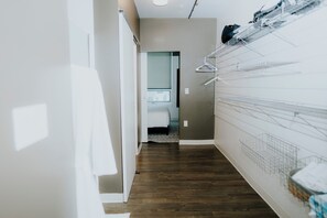 A hallway with a wooden floor, a white wall, and a bed in the background. - Charming 2-bedroom apartment with Balcony/ Garage Parking in Cambridge (Cambridge)