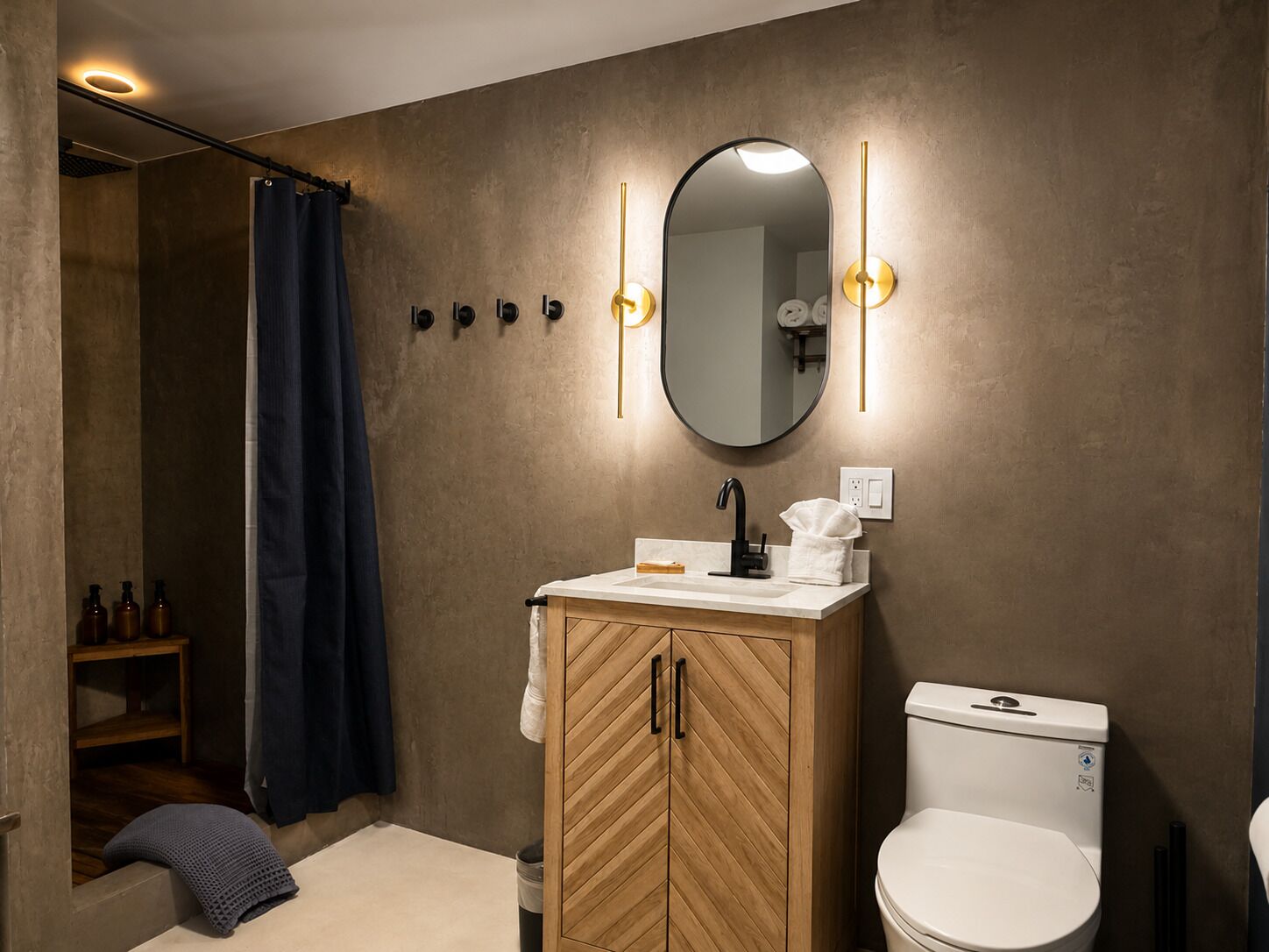A bathroom with a wooden cabinet, a white toilet, a mirror with lights, and a shower curtain.