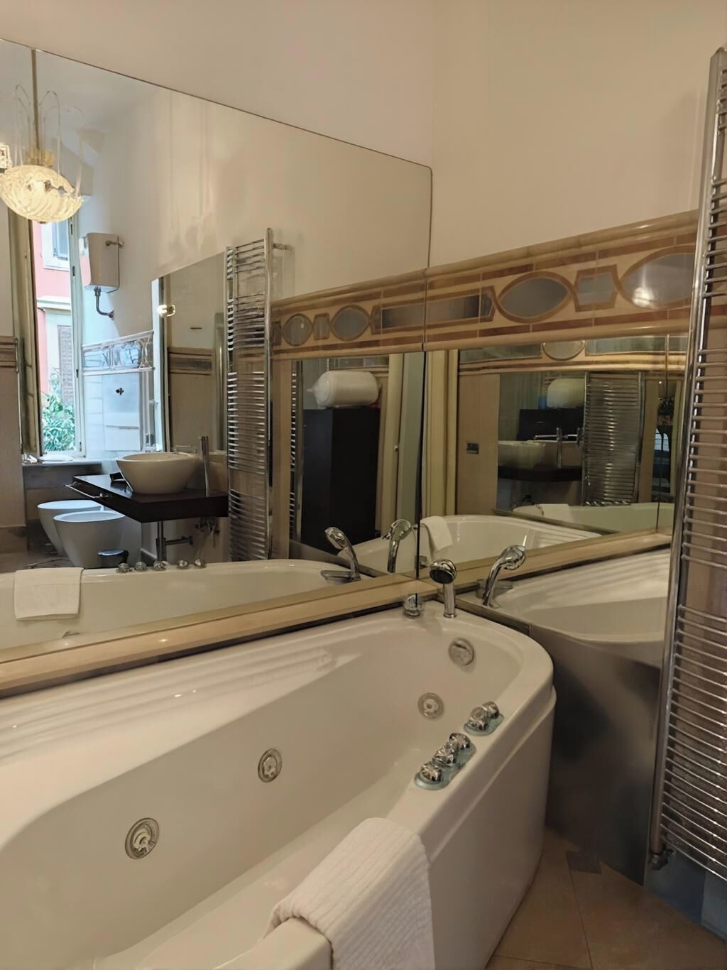 A bathroom with two large tubs, a mirror, and a window.
