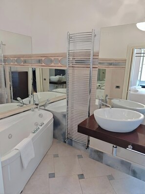 A modern bathroom with a bathtub, a large mirror, a glass shower enclosure, and a vanity with a bowl sink. - Casa Albania Rome (Roma)