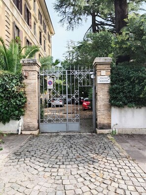 A gated entrance with a cobblestone path leading to a building with a sign reading 'PIAZZA ALBAKIA.' - Casa Albania Rome (Roma)