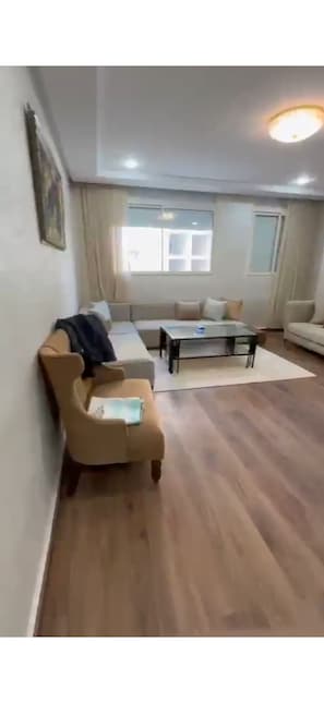 Ein Wohnzimmer mit einer Couch, einem Couchtisch und einem Sessel.
