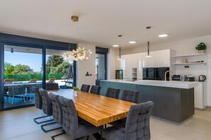 Una cucina moderna con zona pranzo, ampie finestre e vista sull'esterno.