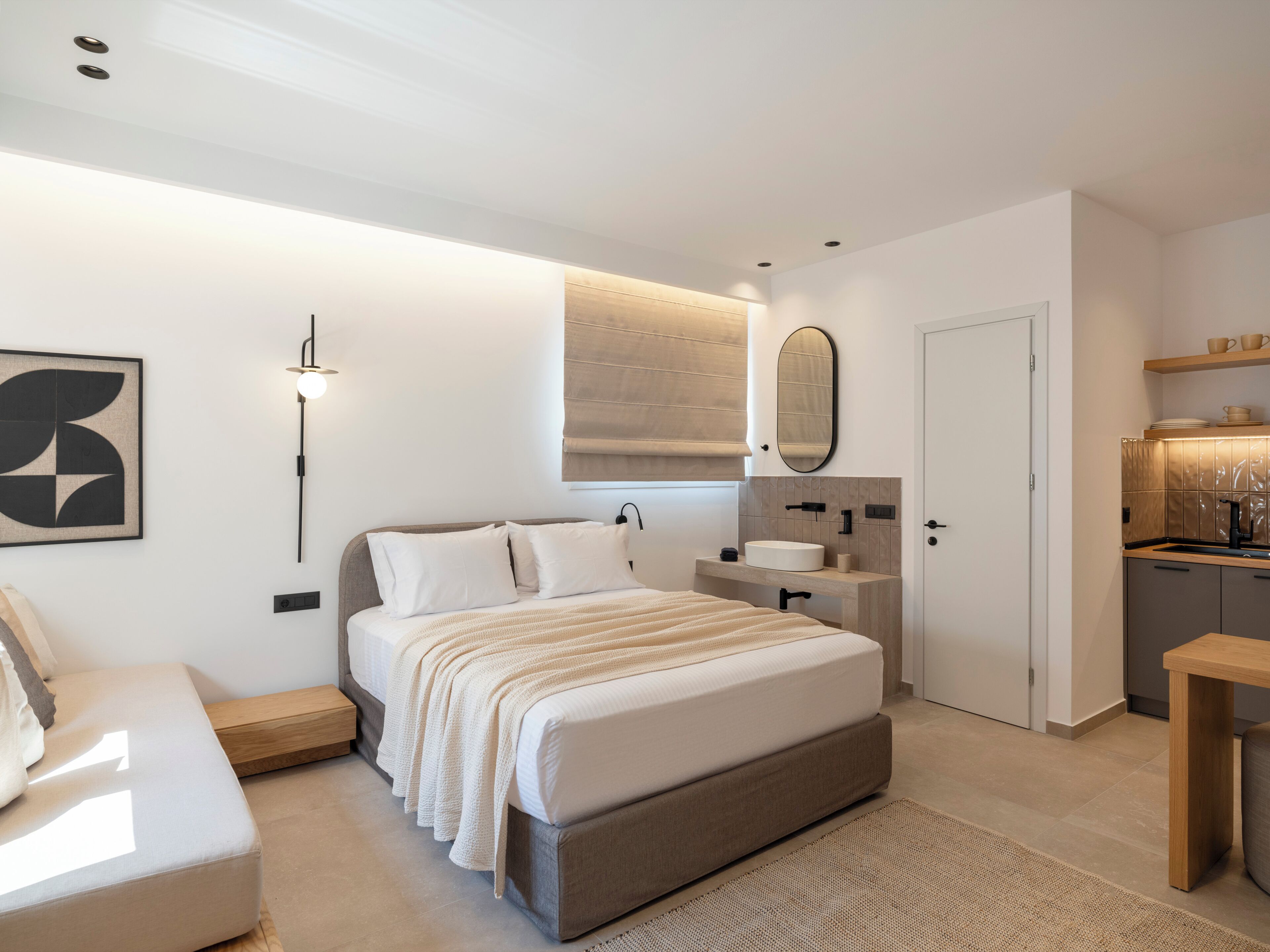 Un dormitorio moderno con cama, mesita de noche y un banco empotrado.
