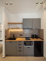 Una cocina moderna con microondas integrado, cafetera y lavavajillas.