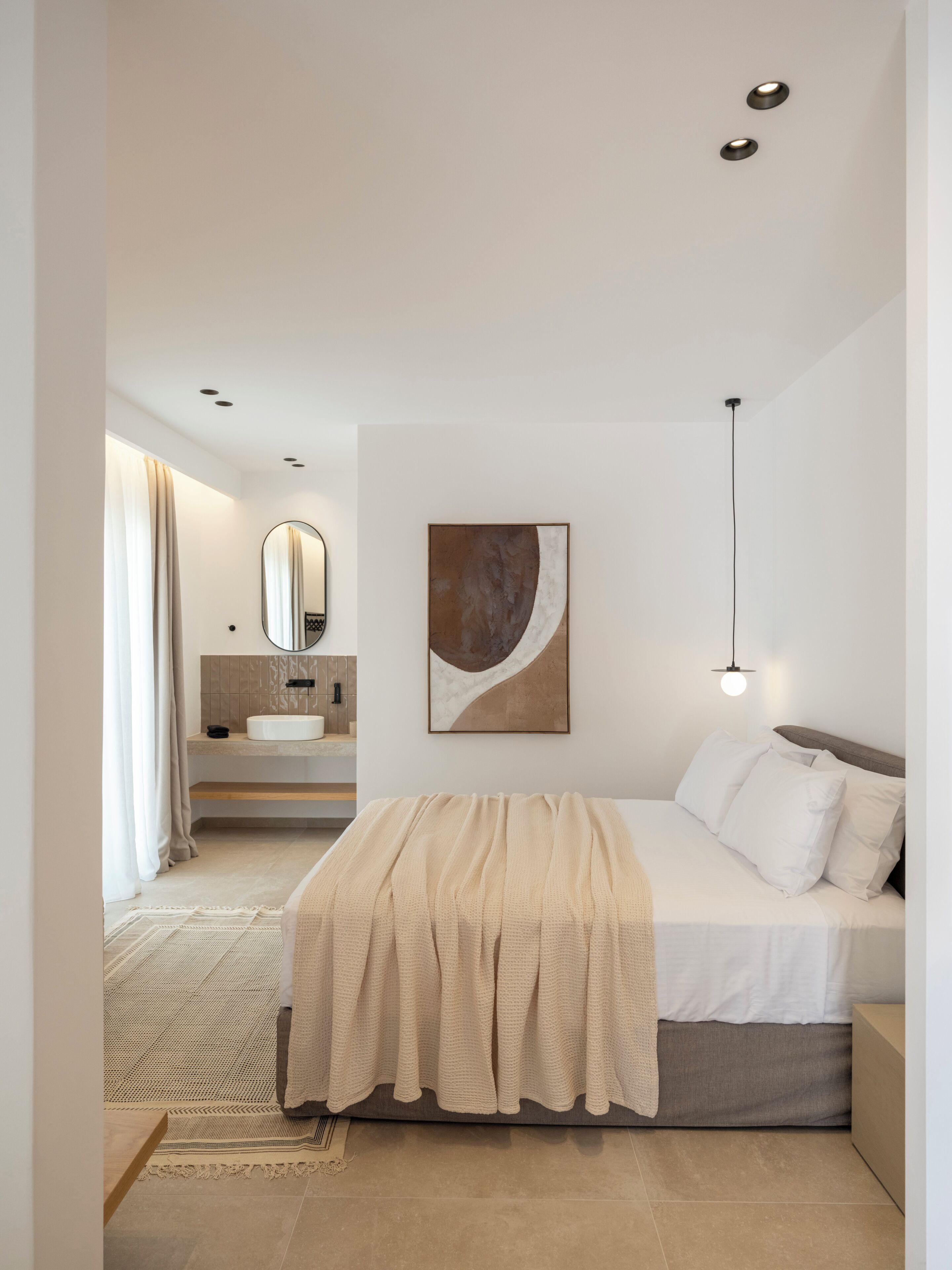 Une chambre à coucher moderne avec un lit, une table de chevet et un grand miroir.