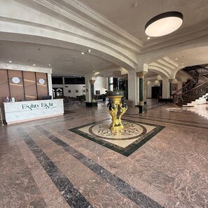 A lobby with a reception desk, a grand staircase, and a decorative fountain. - Eighty Eight Hotel (Tsaghkadzor)