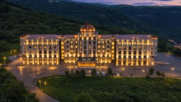 A large hotel with a central dome, multiple floors, and a well-lit facade.