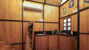 A wooden interior with a kitchen area, a staircase, and a window. - The Buddha Village (Chikkaballapur)