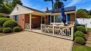 Ein Haus mit überdachter Terrasse, Ziegelaußenwand und einem Kiesweg.