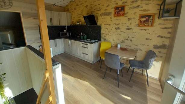 A compact kitchen with wooden cabinets, a microwave, and a dining area with two chairs and a table. - 1 BEDROOM STUDIO GRILLON 2 STEPS FROM THE CENTER (Grillon)