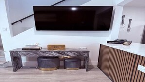 A modern kitchen with a marble countertop, a built-in TV, and a wooden panel wall. - 2-bedroom townhome in quaint Detroit with AC and comfort (Detroit)