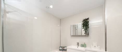 A modern bathroom with a bathtub, a toilet, a sink, and a mirror.