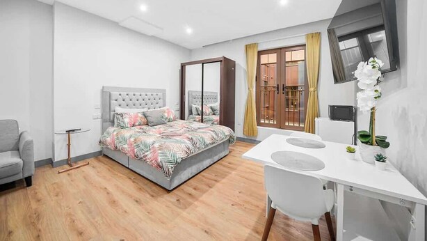 A modern bedroom with a bed, a desk, and a chair. - Stylish Serviced Apartment w/ Rooftop Sky Bar (London)