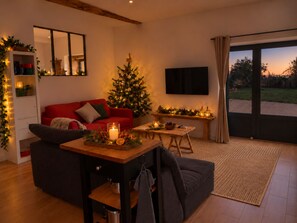 Ein gemütliches Wohnzimmer mit einem roten Sofa, einem Weihnachtsbaum und einem Kamin.