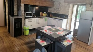 A kitchen with a central island, a microwave, a stove, and a refrigerator. - Lot house in Bouriane (Thédirac)