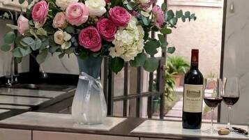Una encimera de cocina con un florero, una botella de vino y dos vasos.