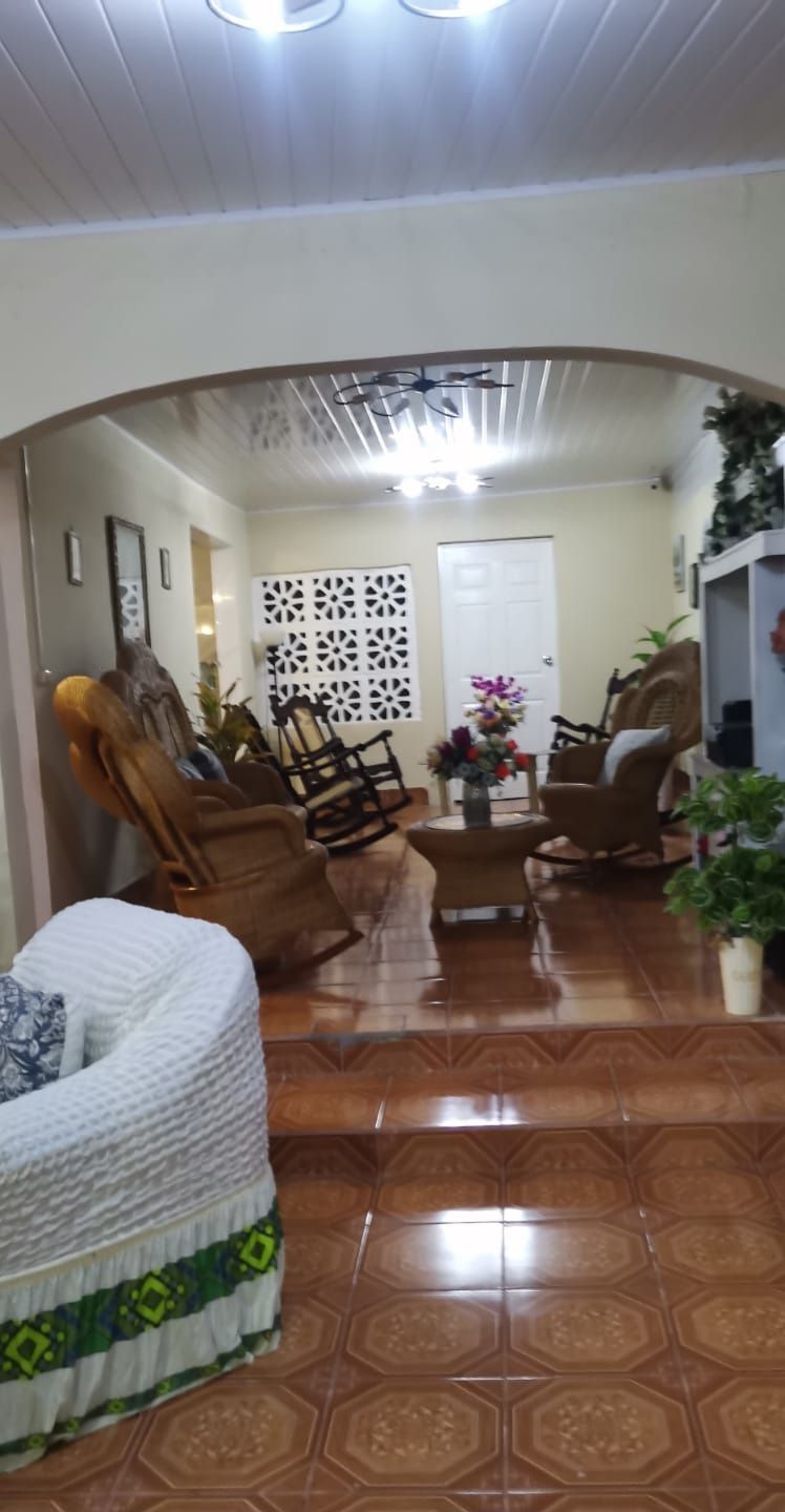 Una sala de estar con un sofá, sillones, una mesa de centro y un panel decorativo en la pared.