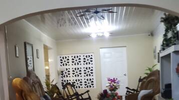 Una sala de estar con un sofá, sillones, una mesa de centro y un panel decorativo en la pared.